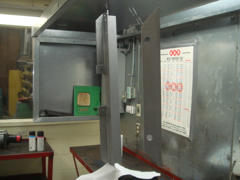Metal brackets and a metric conversion table in a workshop