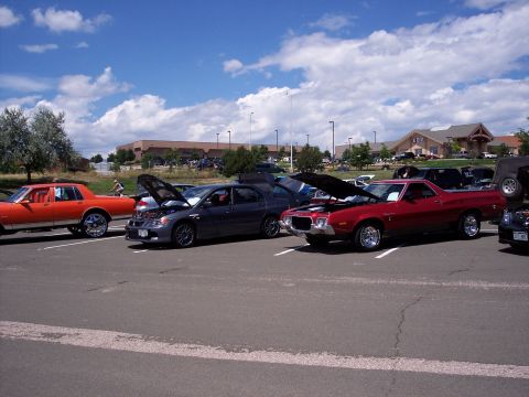 1972 Ford Ranchero - A red 1972 Ford Ranchero is parked with its hood up at an outdoor car show.