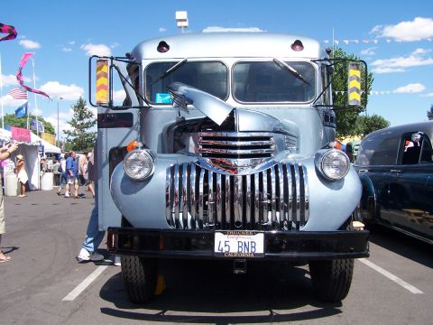 1990 Ford Bronco - A classic truck is parked at an outdoor event with tents and people in the background.