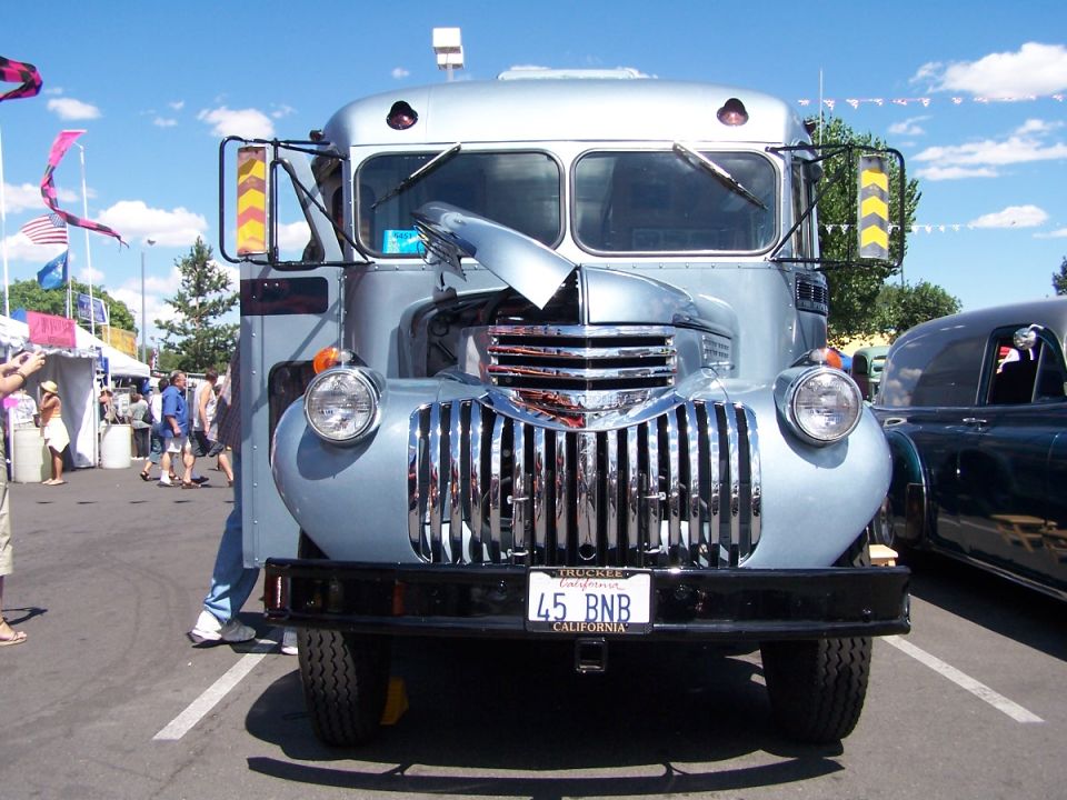 Front view of a silver vintage truck with a chrome grille and California license plate 45 BNB