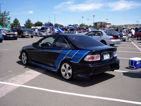 1972 Ford Ranchero - Modified black coupe with blue racing stripes in a parking lot during an event.