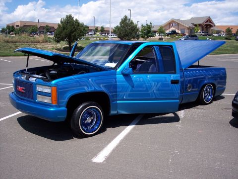 1972 Ford Ranchero - A customized blue GMC pickup truck is parked outside with its hood and bed open, its modifications.