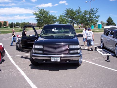 1972 Ford Ranchero - A black pickup truck is parked in a lot with its door open, showing a custom grille and a license plate.