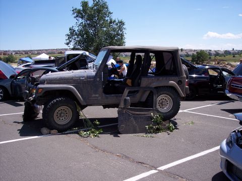 1972 Ford Ranchero - A Jeep Wrangler sits in a parking lot with its doors off, surrounded by other vehicles.