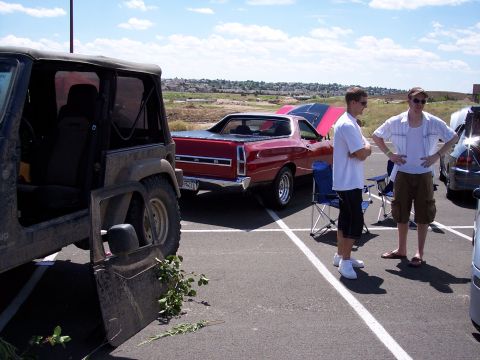 1972 Ford Ranchero - Two men stand near a red coupe utility vehicle with its hood open at an outdoor event.