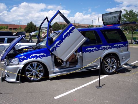 1972 Ford Ranchero - Modified SUV with custom paint and doors displayed at an event.