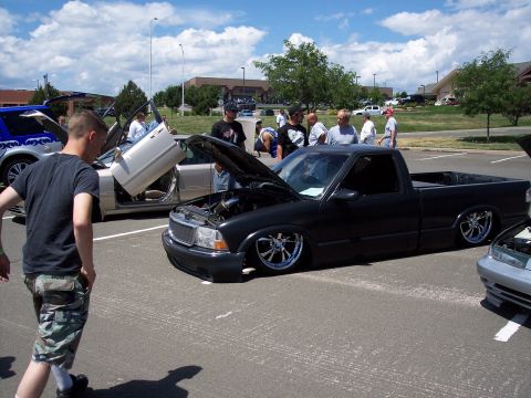 1972 Ford Ranchero - A custom black pickup truck is displayed with its hood and doors open at an outdoor car show.