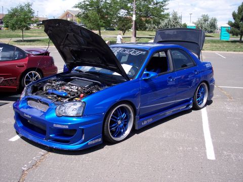 1972 Ford Ranchero - A modified blue Subaru Impreza WRX is displayed with its hood and trunk open, its engine and interior.