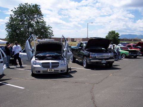 1972 Ford Ranchero - A silver Dodge Magnum with its butterfly doors and hood open is displayed at an outdoor car show.