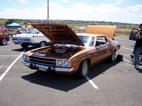 1972 Ford Ranchero - A brown 1974 Plymouth Road Runner is displayed with its hood open at an outdoor car show.