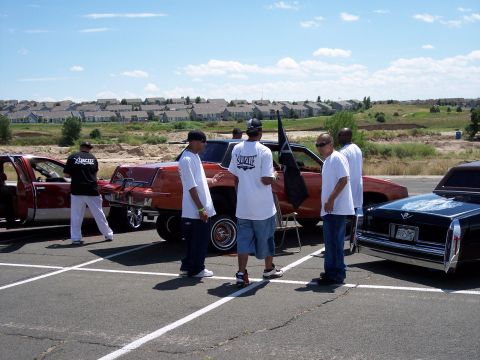 1972 Ford Ranchero - Men socialize around custom cars at an outdoor event.