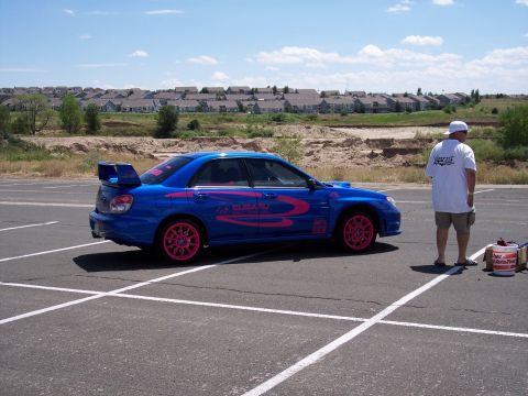 1972 Ford Ranchero - A blue Subaru WRX STI with pink racing stripes and wheels is parked in a lot.