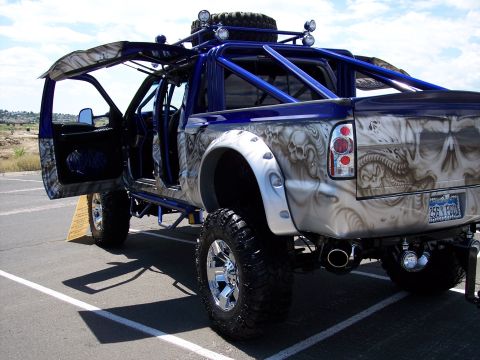 1972 Ford Ranchero - Customized pickup truck with skull airbrushing and open doors, a roll cage and roof-mounted lights.