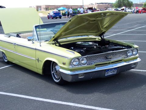 1972 Ford Ranchero - Pale yellow 1963 Ford Galaxie convertible with hood open, parked in a lot.
