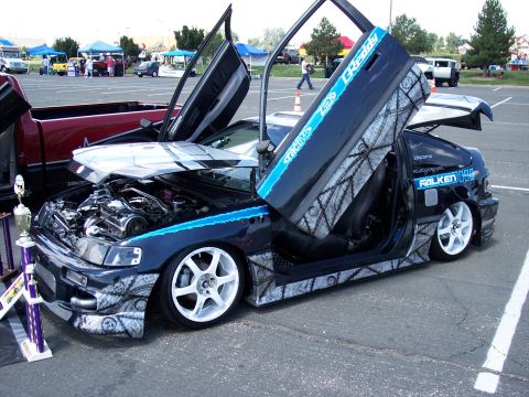 1972 Ford Ranchero - This modified Honda CRX features custom paint, scissor doors, and a visible engine, with a trophy nearby.