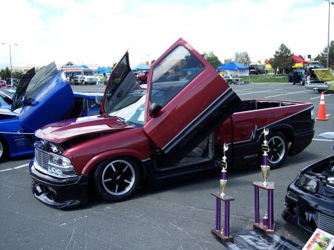 1972 Ford Ranchero - A customized pickup truck with its doors open sits on display at an outdoor event.