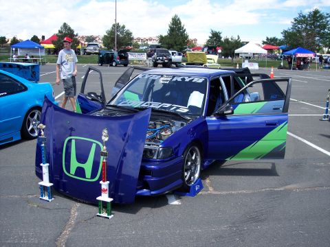 1972 Ford Ranchero - Customized Honda sedan with doors and hood open at an outdoor car show, trophies displayed.