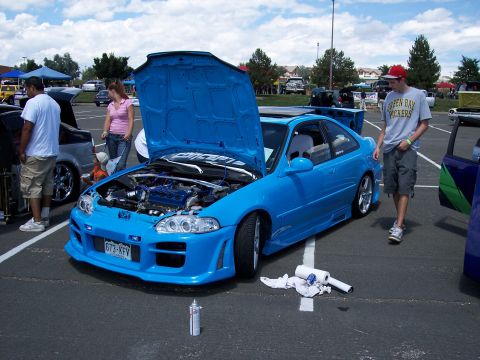 1972 Ford Ranchero - A bright blue Honda Civic coupe is displayed with its hood open, revealing the engine bay, at an outdoor event.