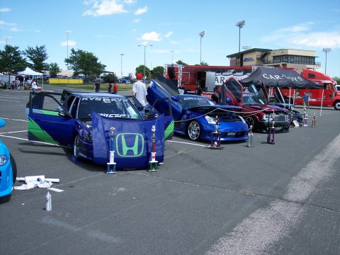 1972 Ford Ranchero - Customized blue car with green accents and butterfly doors displayed at an outdoor event with trophies.