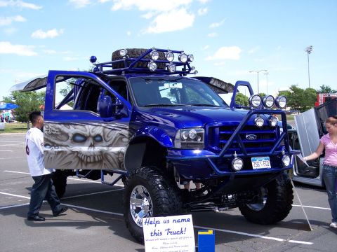 1972 Ford Ranchero - This heavily modified blue Ford F-Series truck features custom skull airbrushing and an aggressive front-end setup.