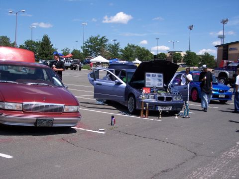 1972 Ford Ranchero - Multiple vehicles are displayed at an outdoor car show under a partly cloudy sky.