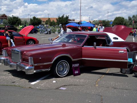 1972 Ford Ranchero - Maroon 1977 Lincoln Continental Mark IV displayed with doors open at a car show.