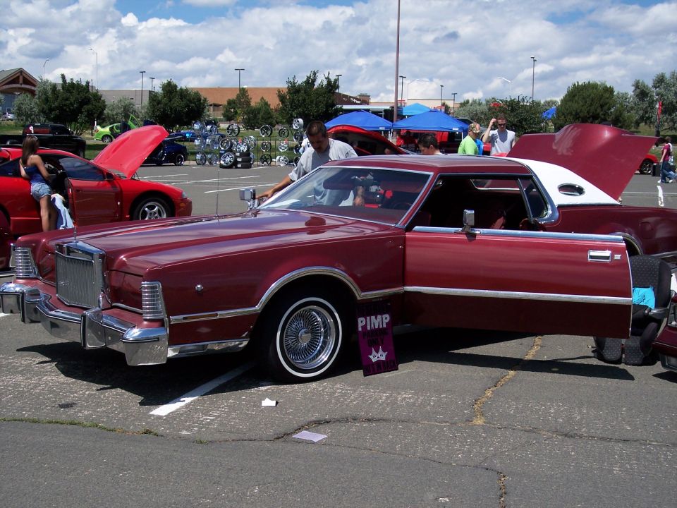 Maroon 1977 Lincoln Continental Mark IV with doors open, parked at an outdoor car show