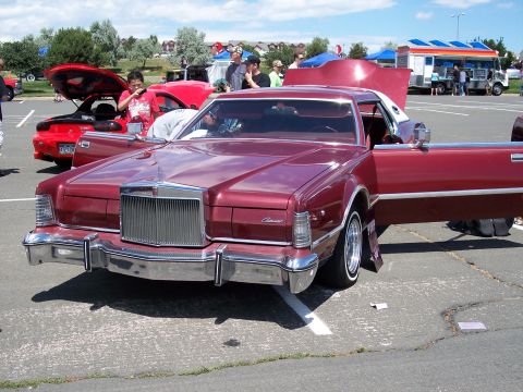 1972 Ford Ranchero - A large maroon Lincoln Continental Mark V is displayed with its doors open at an outdoor event.