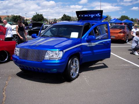 1972 Ford Ranchero - Customized blue SUV on display at an outdoor car show with other vehicles present.