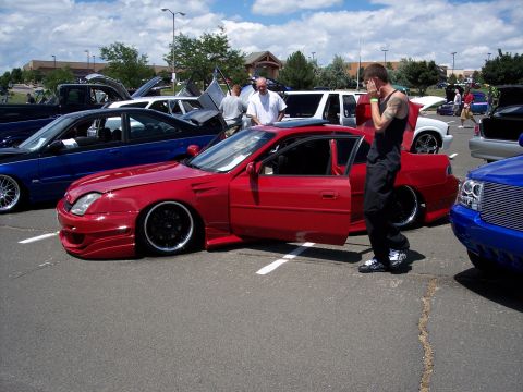 1972 Ford Ranchero - A red coupe is displayed with its doors open at an outdoor car event.