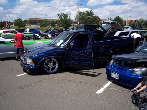 1972 Ford Ranchero - A customized blue pickup truck with flame decals and lowered suspension is displayed at an outdoor event.