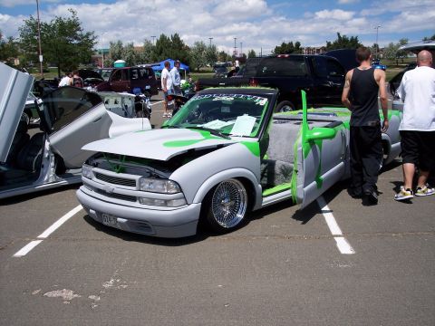 1972 Ford Ranchero - A customized pickup truck with its hood and doors open is parked in a lot with other vehicles.