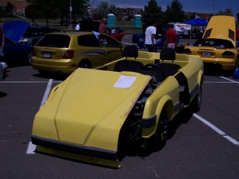 1972 Ford Ranchero - A yellow custom car sits with its hood open, revealing its engine components.