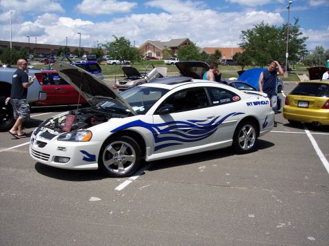 1972 Ford Ranchero - A white coupe with blue flame decals is displayed with its hood open at an outdoor car show.