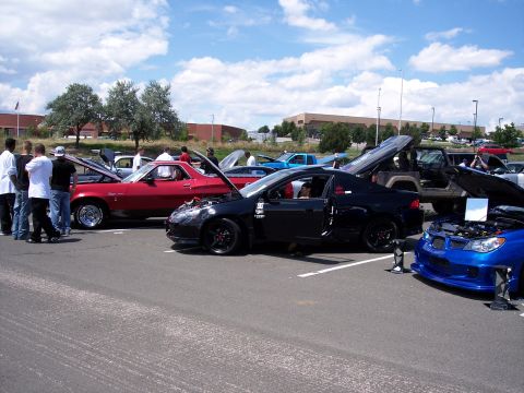 1972 Ford Ranchero - A collection of modified cars are on display at an outdoor event under a partly cloudy sky.