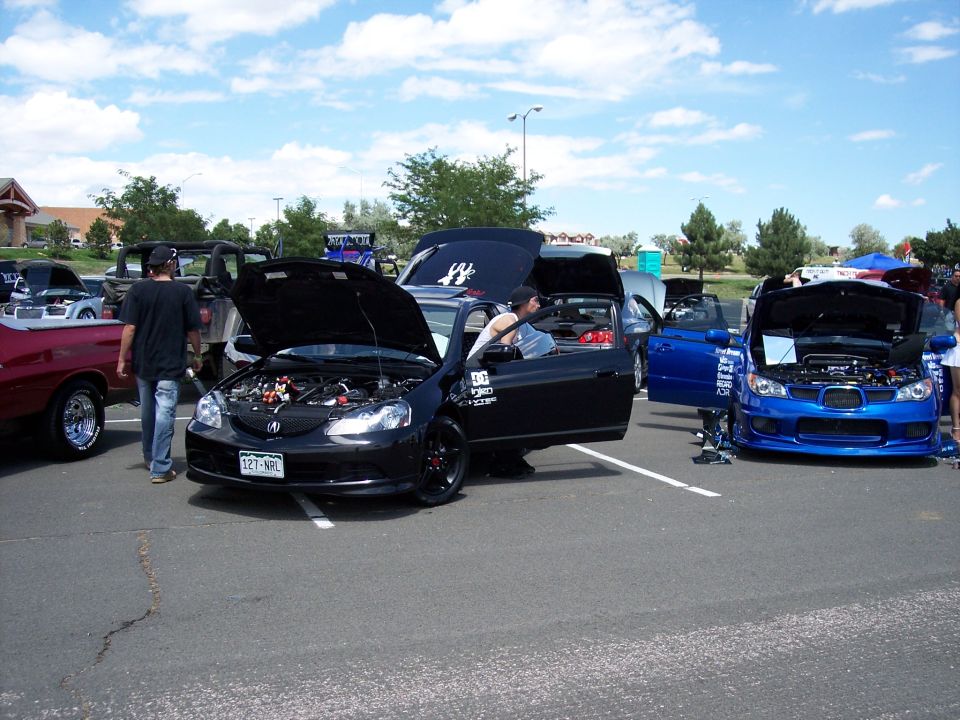 Black Acura RSX with hood open, showing engine and custom modifications
