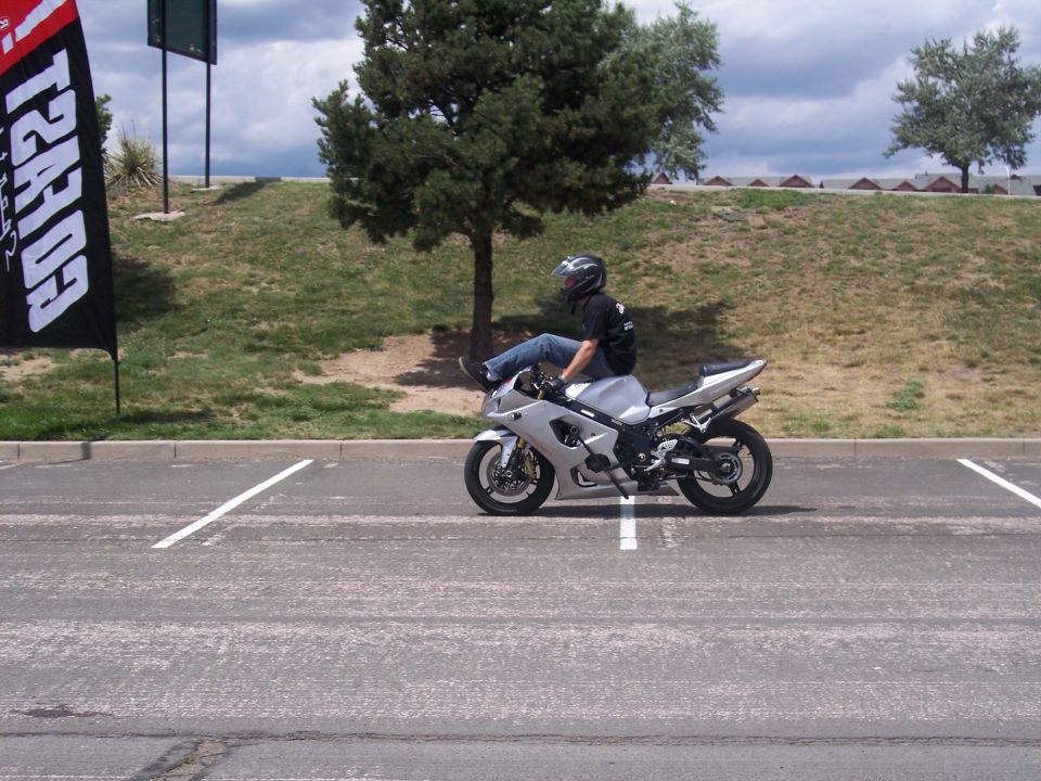 Silver sport motorcycle side view with rider's legs extended