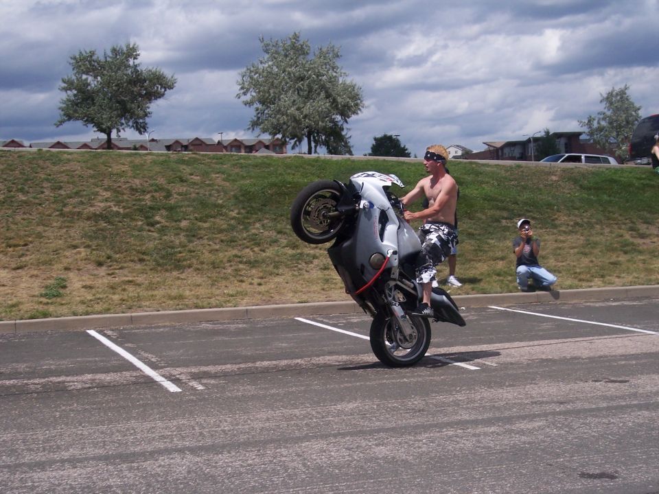 Motorcycle doing a wheelie in a parking lot