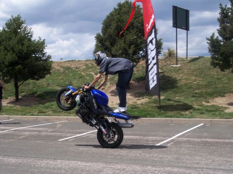 1972 Ford Ranchero - Motorcyclist performs a wheelie on a blue sportbike, with a large banner visible in the background.
