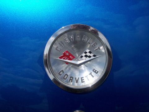 1972 Ford Ranchero - A circular Chevrolet Corvette emblem with crossed flags is shown on a blue metallic surface.