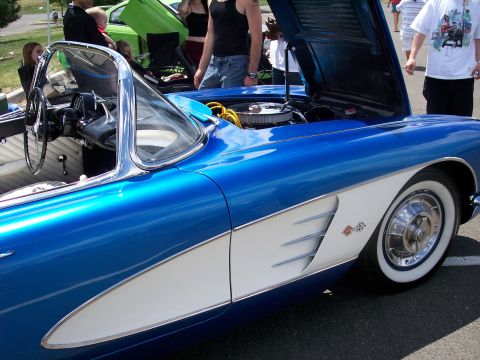 1972 Ford Ranchero - A classic 1958 Chevrolet Corvette is displayed with its hood open at an outdoor car show.