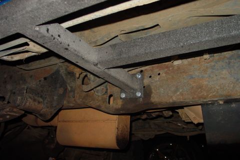 1993 Ford Bronco - The undercarriage of a vehicle shows significant rust on the frame and some aftermarket modifications.