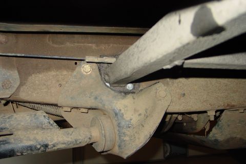 1993 Ford Bronco - Underside view of a vehicle's frame and suspension system, showing various metal components and bolts.