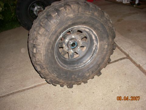 2000 Chevrolet Tahoe - A close-up view of a single off-road tire and wheel, a black rim and tread pattern.