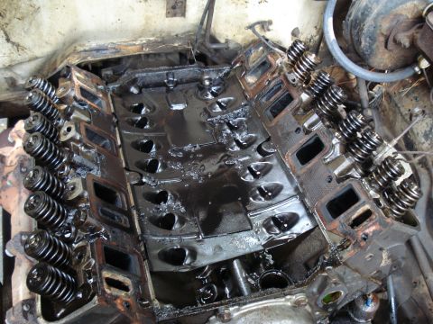 1967 Ford F-250 - Close-up of an engine block with valves and springs, covered in oil.