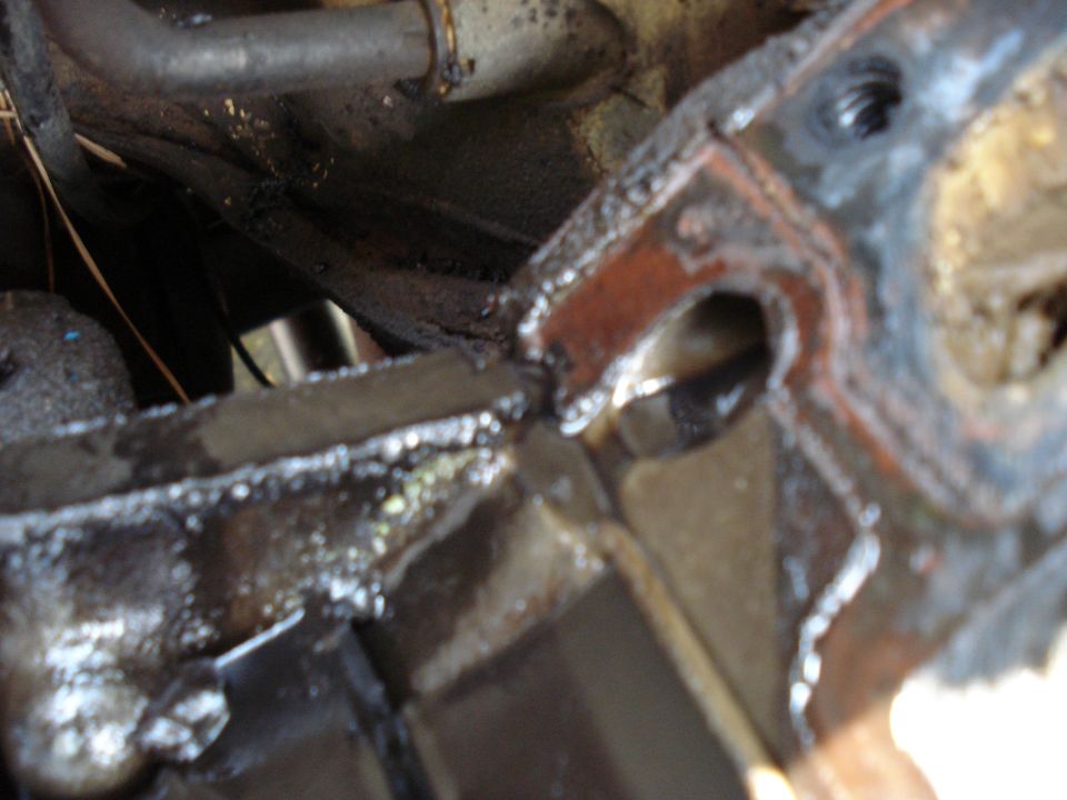 close-up of greasy engine component with metal pipes