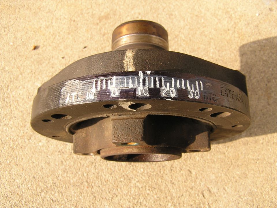 Ford harmonic balancer with timing marks and casting number E4TE-A3A on concrete