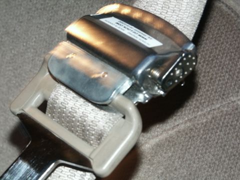 2001 Mercury Grand Marquis - A CG-Lock device is attached to a vehicle's seatbelt buckle, with visible text on the device.
