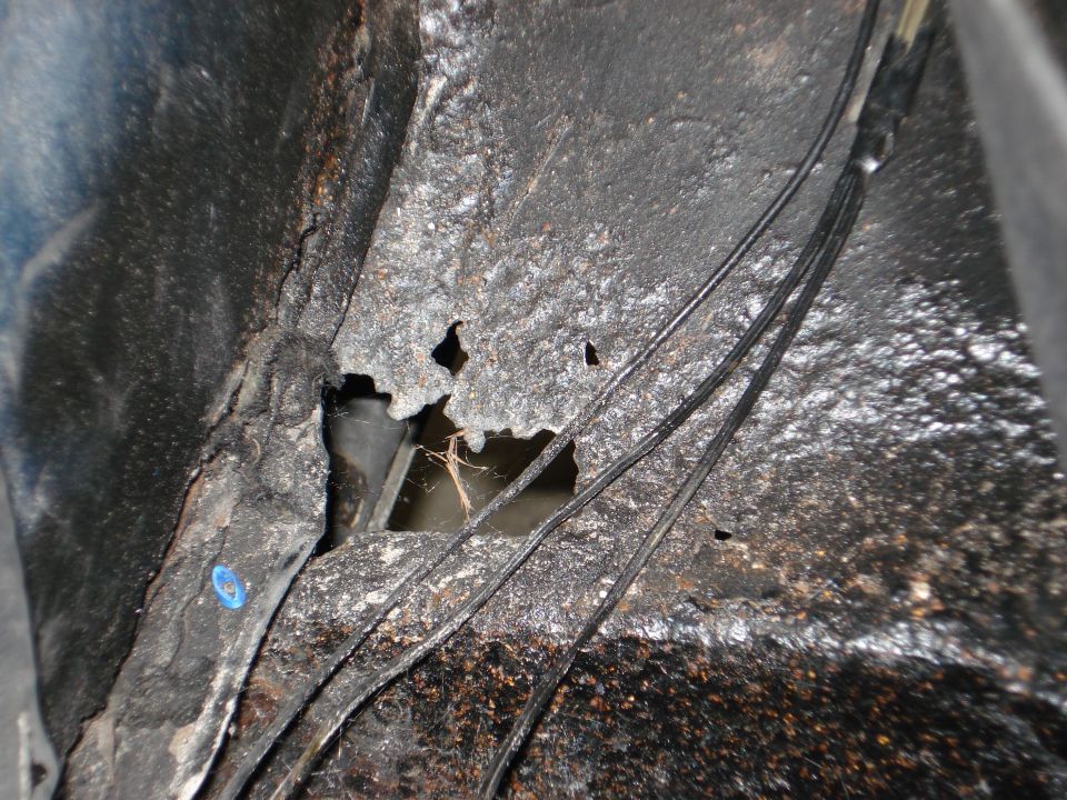Close-up of rusted metal with holes and wires