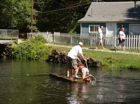 1986 Ford Bronco - A group of people are enjoying a day on a raft in the water near a house.